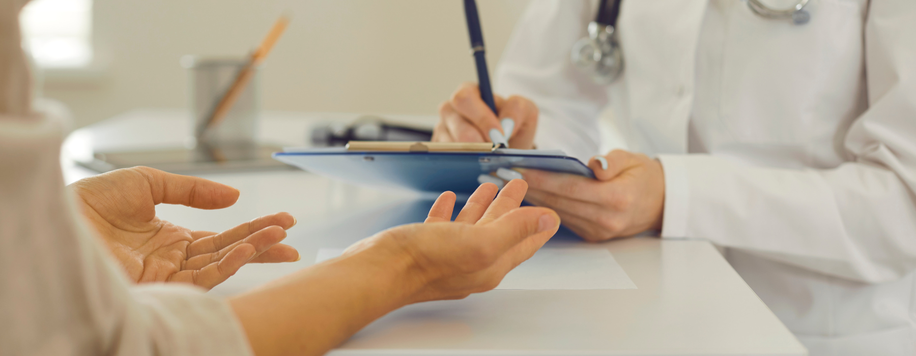 Médico preenchendo prontuário com paciente à frente, representando a aplicação de tecnologia e processos na gestão em saúde.