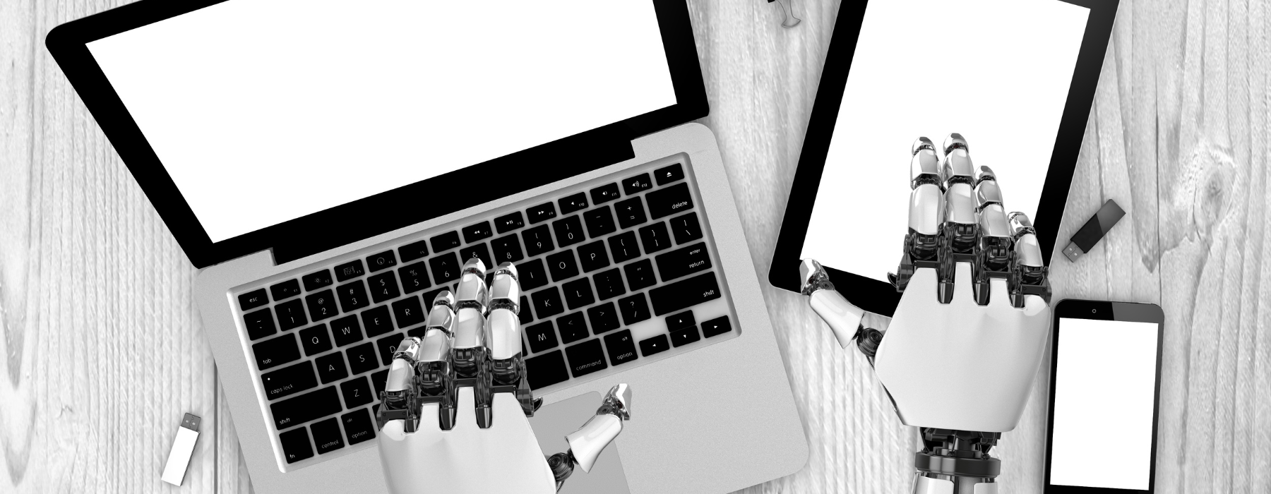 Mãos robóticas usando um laptop e um tablet sobre uma mesa de madeira, com telas em branco.