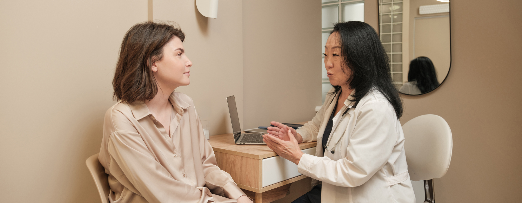 Médica conversando com paciente em um consultório, ilustrando atendimento humanizado apoiado pela tecnologia.