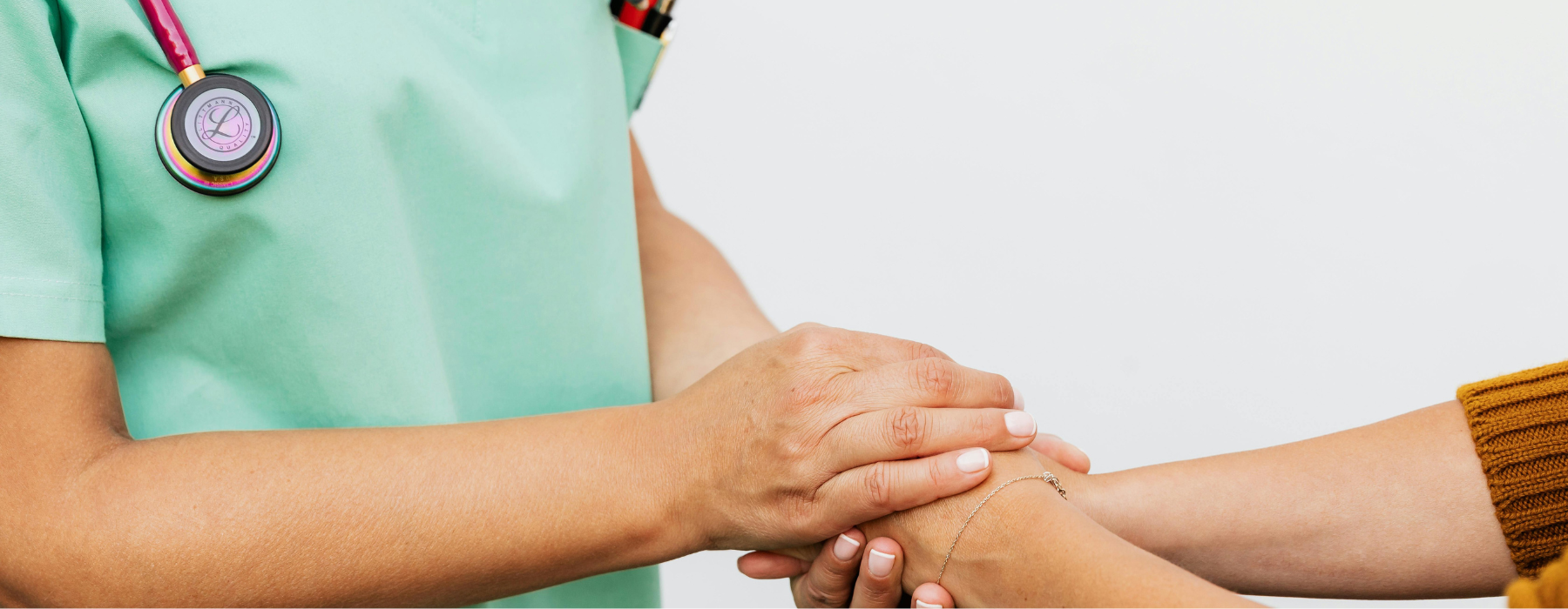 Profissional de saúde segurando a mão de um paciente em gesto de apoio e cuidado.