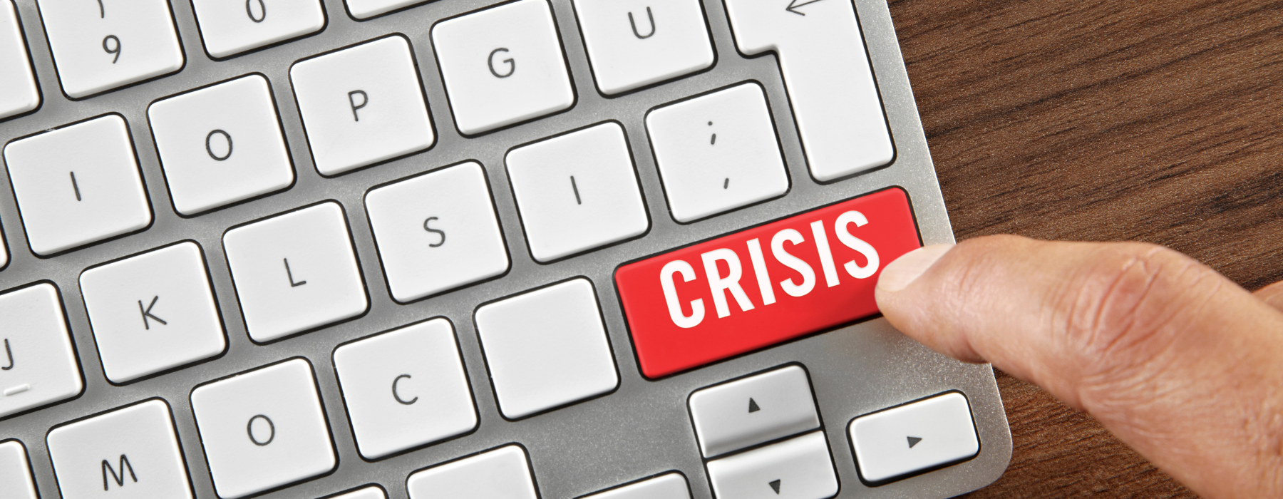 Dedo pressionando uma tecla vermelha escrita “crisis” em um teclado, simbolizando a importância do timing na tomada de decisões durante crises digitais.